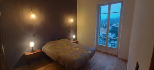 une chambre avec un lit et une grande fenêtre dans l'établissement Elégant, Lumineux,Central 2pièces à 200m de la mer, à Menton