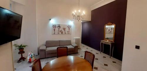 uma sala de estar com uma mesa, um sofá e um espelho em Elégant, Lumineux,Central 2pièces à 200m de la mer em Menton