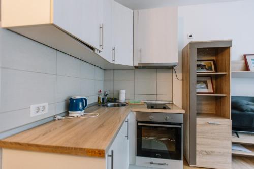 a kitchen with white cabinets and a wooden counter top at Studio Apartmani Donnie in Livno