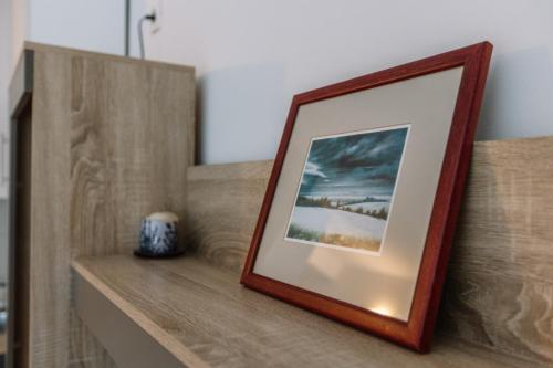 a picture frame sitting on top of a wooden shelf at Studio Apartmani Donnie in Livno