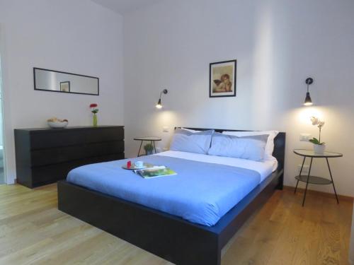 una camera da letto con un grande letto con lenzuola blu di Santa Croce Apartments a Bologna