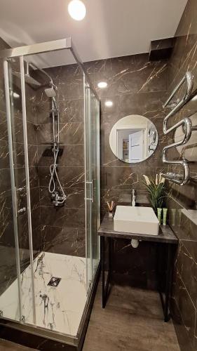 La salle de bains est pourvue d'un lavabo et d'une douche. dans l'établissement Apartamentai su balkonu prie Akropolio Nr 2, à Klaipėda