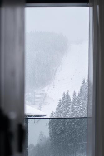 a view of a snow covered ski slope from a window at SAVOIE Apartments Bukovel in Bukovel