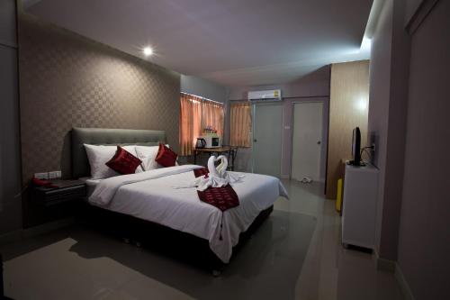 a bedroom with a large white bed with red pillows at NRC Residence in Lat Krabang