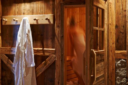 a woman standing in a wooden room with a door at Exclusive Chalet Grumer 700 sqm in Soprabolzano