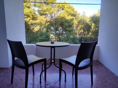 a table and two chairs in front of a window at Evita Blue in Xylokastron