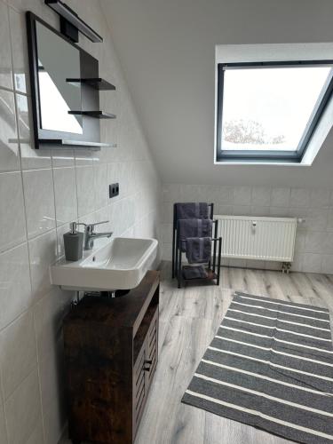 a white bathroom with a sink and a window at Ferienwohnung Zeitz - Weiße Elster Apartment Nr 9 in Zeitz