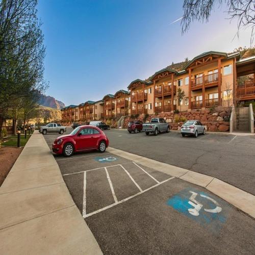 a red car parked in a parking lot with buildings at Hotel De Novo Springdale, Tapestry Collection by Hilton in Springdale