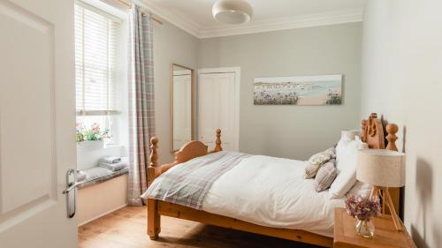 a bedroom with a bed and a table and a window at Sea Sound in Cellardyke