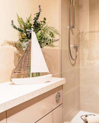 a bathroom with a shower and a model boat on a counter at Sea Sound in Cellardyke