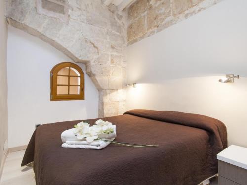 a bedroom with a bed with towels and flowers on it at Apartamento Sa Calatrava in Palma de Mallorca