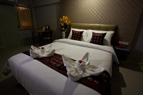 a hotel room with two beds with towels on them at NRC Residence in Lat Krabang