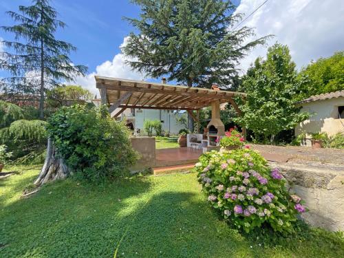 a garden with a wooden pergola and some flowers at Appartamenti Adriana di ArgonautiVacanze in Porto Azzurro
