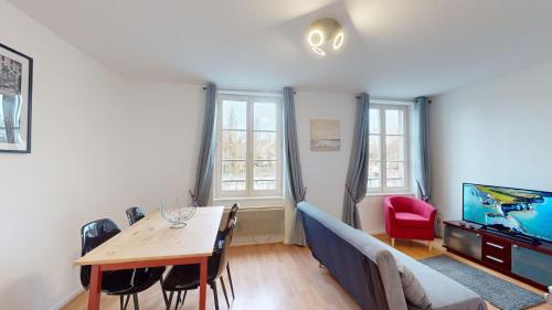 un salon avec une table et une télévision dans l'établissement Au bord de l’eau, à Strasbourg