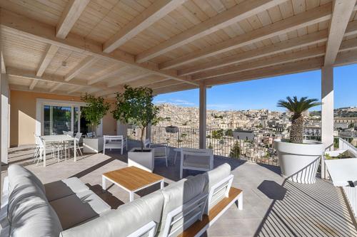 a patio with white furniture and a view of the city at Itria Modica in Modica
