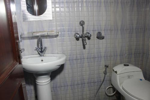 a bathroom with a sink and a toilet at Hotel Happy Home or Mudkhu Durbar in Kathmandu