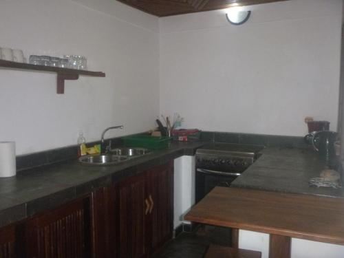 a kitchen with a sink and a stove at LOCAVACATION Les Hauts Manguiers Villa 15 in Ambondrona