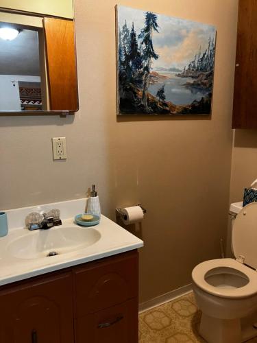 La salle de bains est pourvue de toilettes et d'une peinture murale. dans l'établissement Silver Valley Getaway, à Kellogg