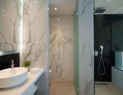a bathroom with a white sink and a shower at San Marco Hotel and Villas in Houlakia