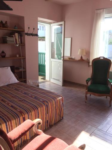 a bedroom with a bed and a chair and a window at Maisonnette studio centre de St JeanPied de port in Saint-Jean-Pied-de-Port