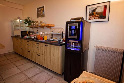 een keuken met een bar en een drankdispenser bij Contact Hôtel - Hôtel Le Lion d'Or Lamballe in Lamballe