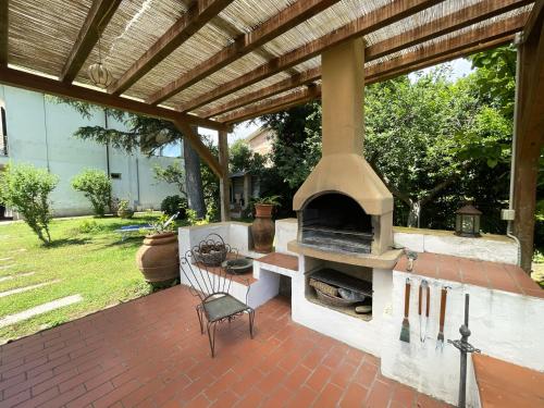 a patio with an outdoor oven with a chair at Appartamenti Adriana di ArgonautiVacanze in Porto Azzurro
