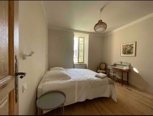 une chambre avec un lit et une table dedans dans l'établissement Le Petit Palais de Chaillot 8 places 4 chambres spacieuses, à Colonzelle