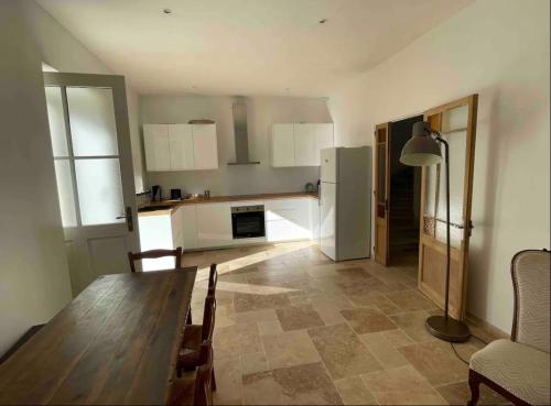 - une cuisine avec une table en bois dans une chambre dans l'établissement Le Petit Palais de Chaillot 8 places 4 chambres spacieuses, à Colonzelle