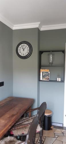 a clock hanging on a wall above a table at Tina`s home in Gütersloh