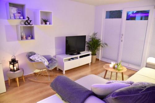 un soggiorno con un divano e una TV di Anzère, appartement cozy au coeur des Alpes ad Anzère