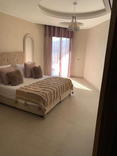 1 dormitorio con 1 cama grande y ventana en Appartement neuf climatisé, centre Marrakech., en Marrakech