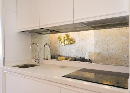 a kitchen with white cabinets and a sink at Living4malaga Atico Marina in Málaga