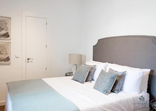a bedroom with a bed with blue and white pillows at Living4malaga Atico Marina in Málaga