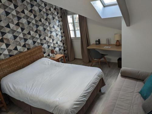 a bedroom with a bed and a table and a desk at Contact Hôtel - Hôtel Le Lion d'Or Lamballe in Lamballe