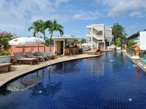 ein Swimmingpool mit Stühlen und Sonnenschirmen neben einem Gebäude in der Unterkunft Karon Princess Hotel SHA EXTRA Plus in Karon Beach
