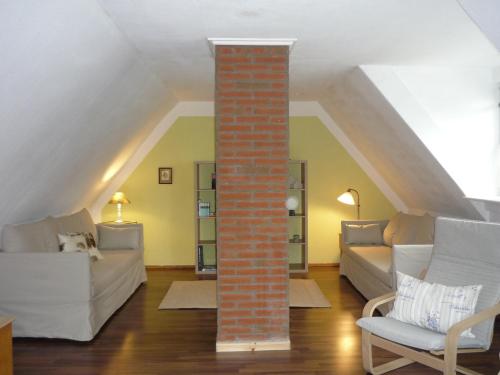 a living room with a brick pillar in the attic at Husly Gondesen in Sörup