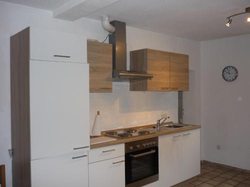 a kitchen with white cabinets and a stove top oven at Husly Gondesen in Sörup