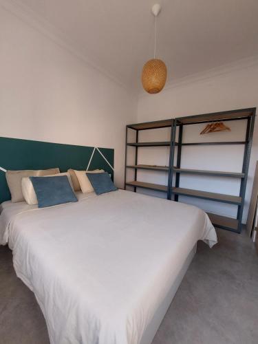 a bedroom with a large white bed with blue pillows at Sara's apartment Barcelona in El Prat de Llobregat
