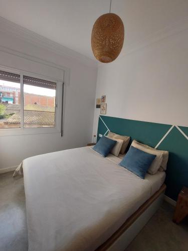 a bedroom with a large bed with blue pillows at Sara's apartment Barcelona in El Prat de Llobregat