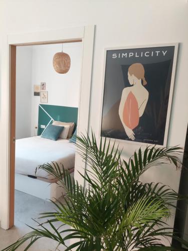 a bedroom with a bed and a poster of a woman at Sara's apartment Barcelona in El Prat de Llobregat