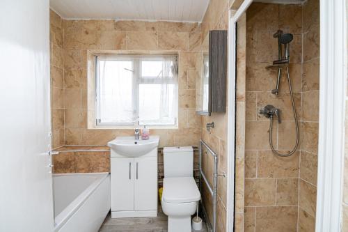 Impeccable 3-Bed House in Abbeywood في لندن: حمام مع مرحاض ومغسلة ودش