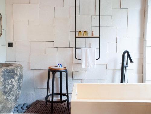 a bathroom with a bathtub and a stool next to a bath tub at The Forest Museum in Zhuolan