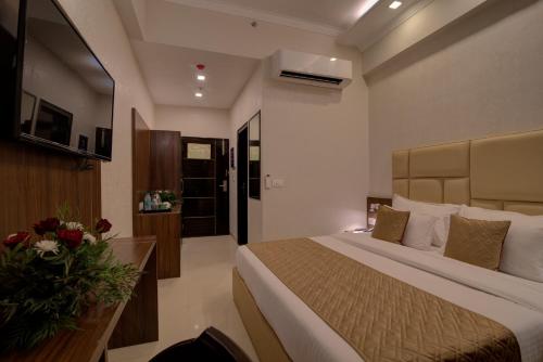 a hotel room with a bed and a vase of flowers at Comfort Inn Karnal in Taraori