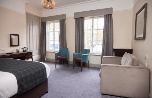 オールトンにあるSwan Hotel by Greene King Innsのベッド、ソファ、椅子が備わるホテルルームです。