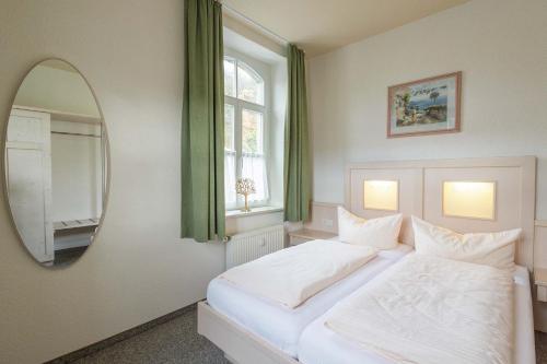 バート・シャンダウにあるFerienwohnung zur Steinburgのベッドルーム(白いベッド1台、鏡付)