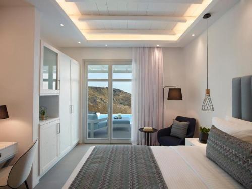 a bedroom with a bed and a view of the ocean at San Marco Hotel and Villas in Houlakia