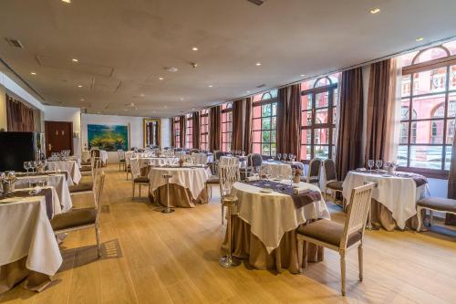 - une salle de banquet avec des tables, des chaises et des fenêtres dans l'établissement Hotel Blancafort Spa Termal, à La Garriga