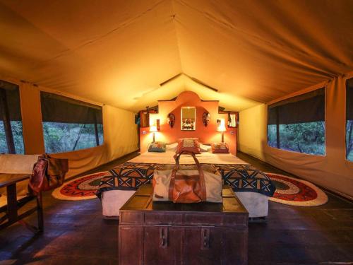 a large room with a bed in a tent at Kilima Camp - Safari in Masai Mara in Lolgorien