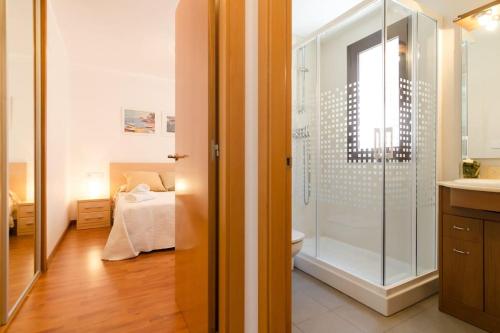 a bathroom with a shower and a bedroom with a bed at Apto. Corona 5 huéspedes in Lloret de Mar