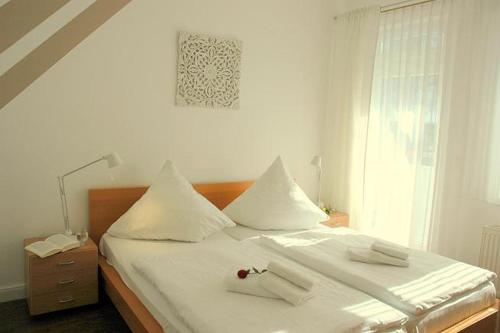 a bedroom with a bed with white sheets and a window at Villa Amanda by Rujana in Binz